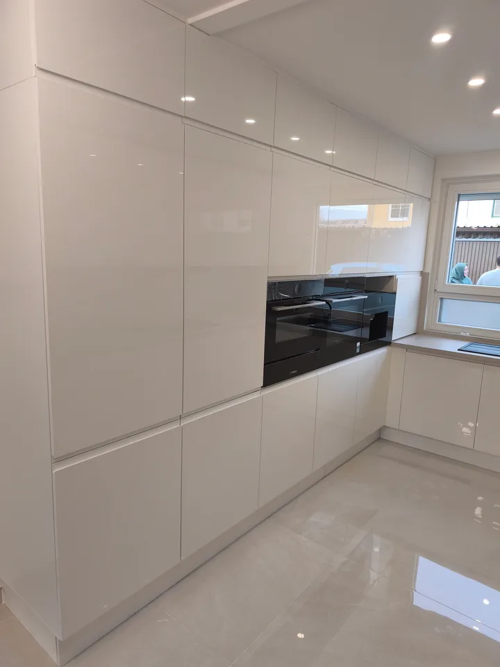 Tall units with white gloss doors and black built-in appliances